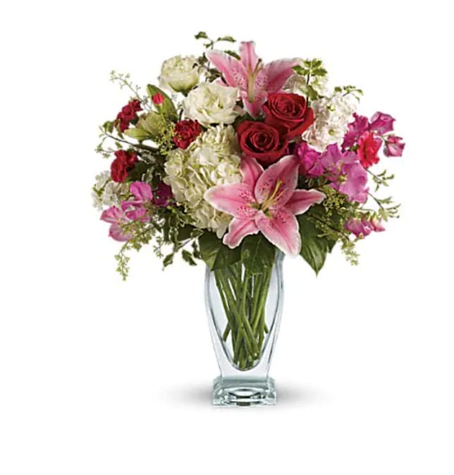 Pink lilies and red roses in a clear glass vase