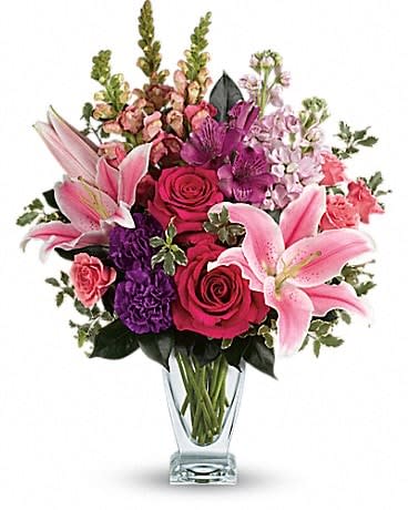 Pink lilies and roses in a clear glass vase