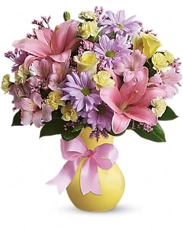 Pink and lavender mixed bouquet in a yellow vase with a pink ribbon