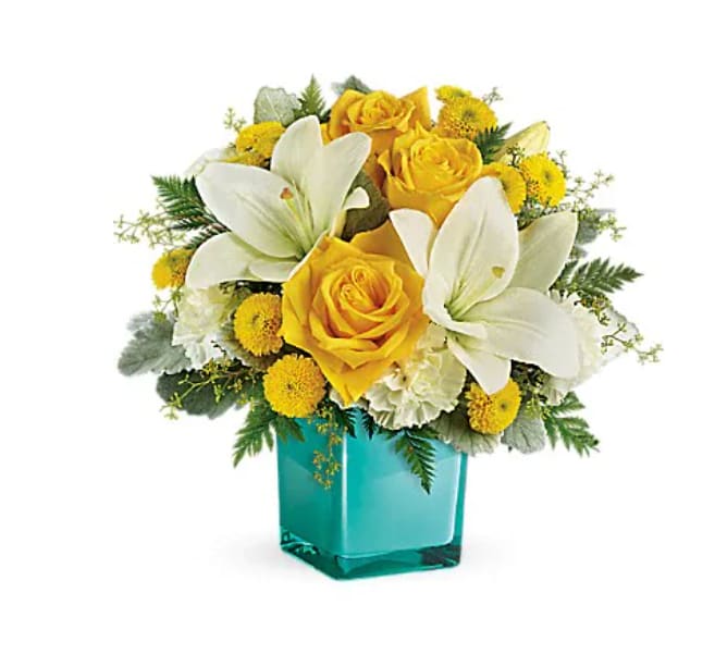 Yellow roses and white lilies in a turquoise glass vase