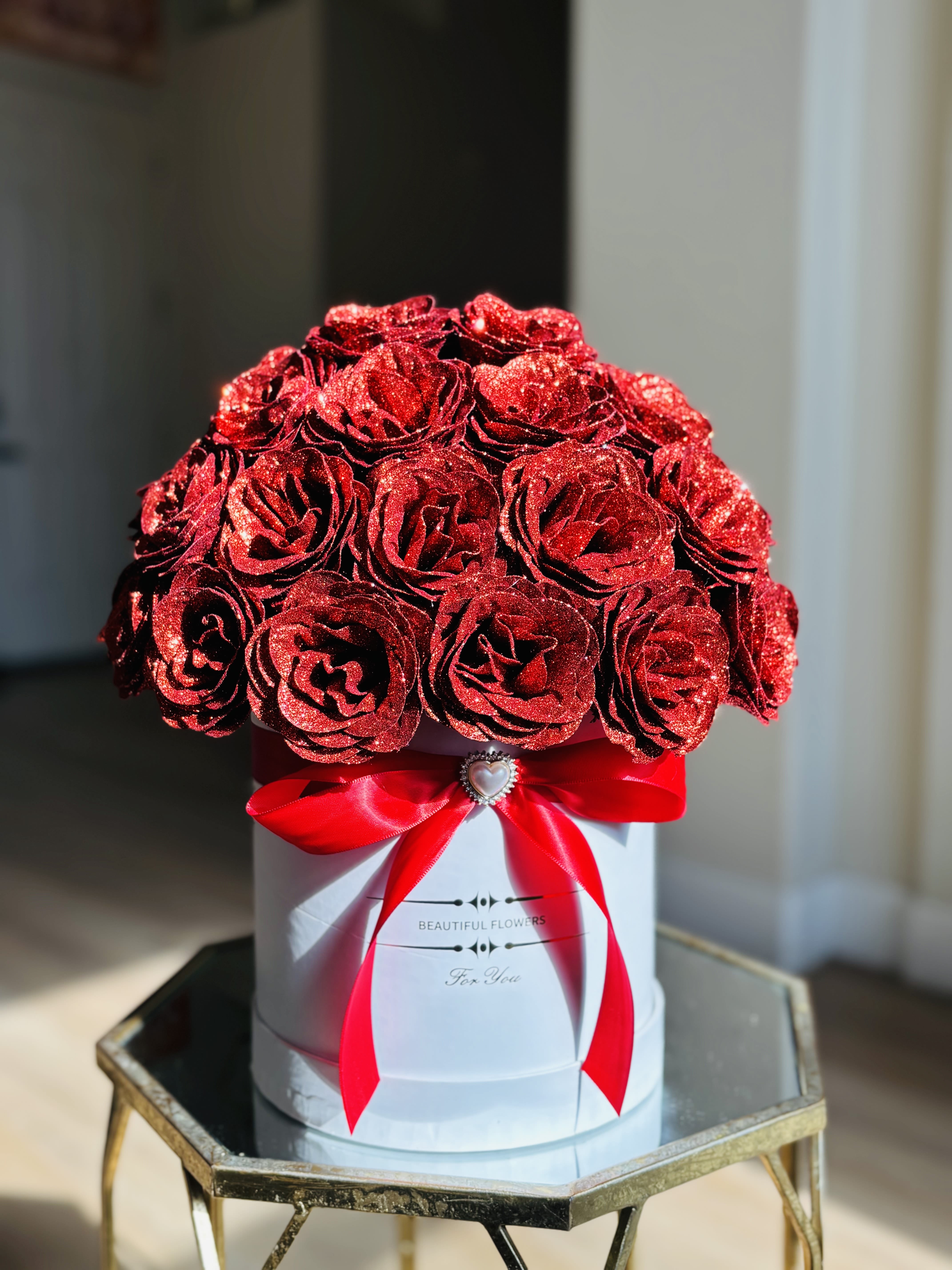 Red glitter roses in a white hat box with a red ribbon