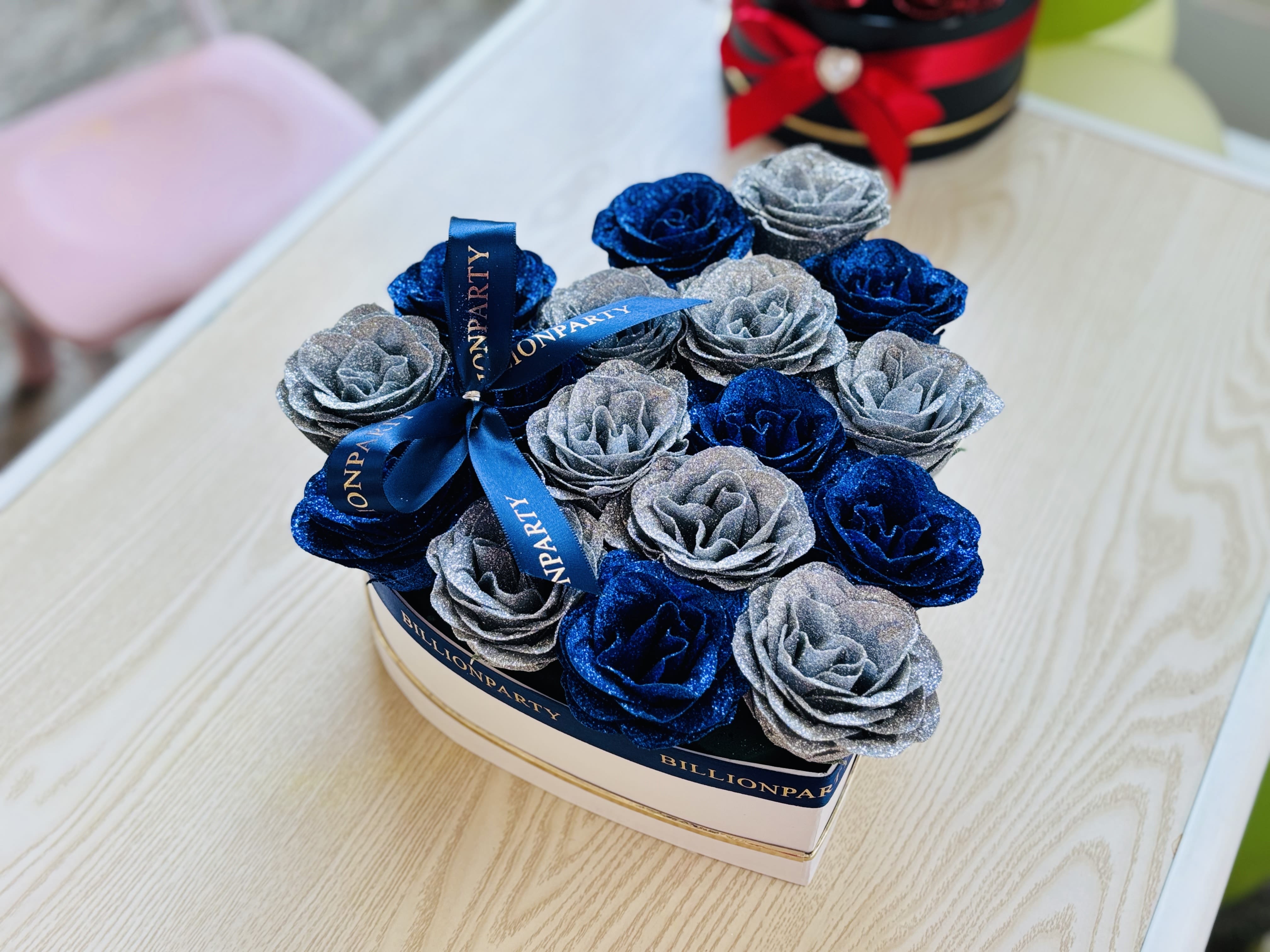 Box of glittery blue and silver roses tied with a ribbon
