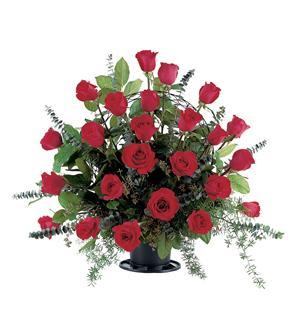 Red roses arranged in a black vase with greenery