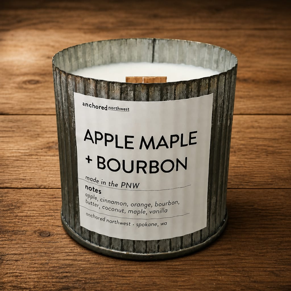 Apple Maple + Bourbon candle in a metal tin on a wooden surface