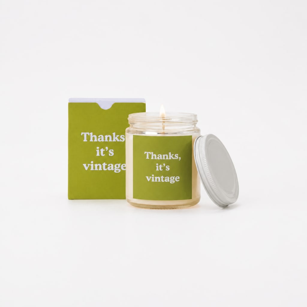 Lit candle in a glass jar with a matching box