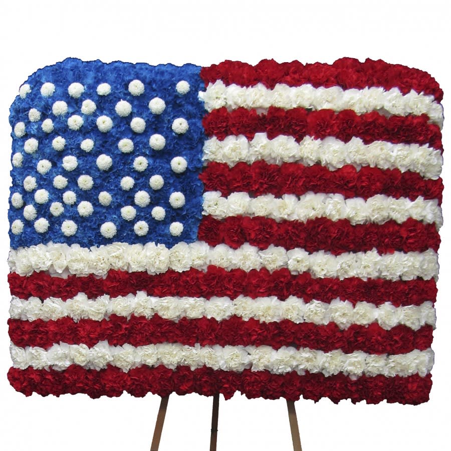 Floral arrangement shaped like the American flag on a stand