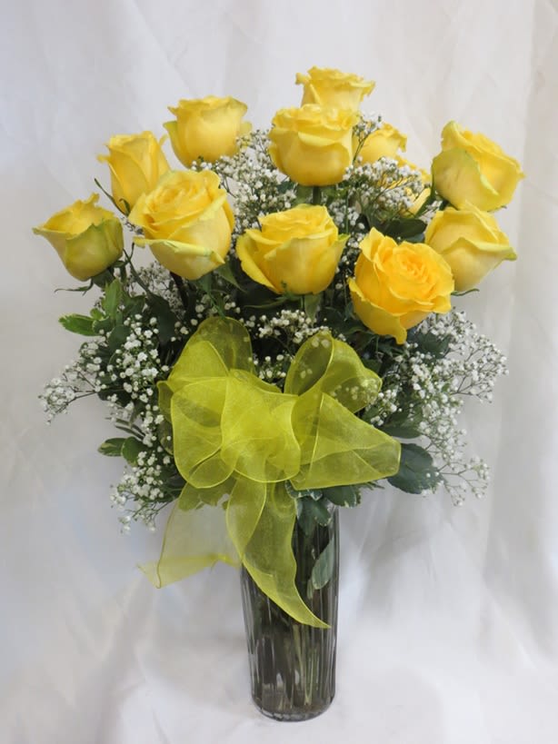 Yellow roses in a clear glass vase with a yellow ribbon
