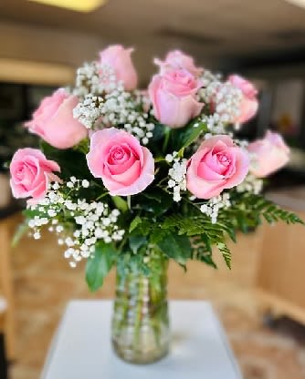 Pink roses and baby's breath in a clear glass vase