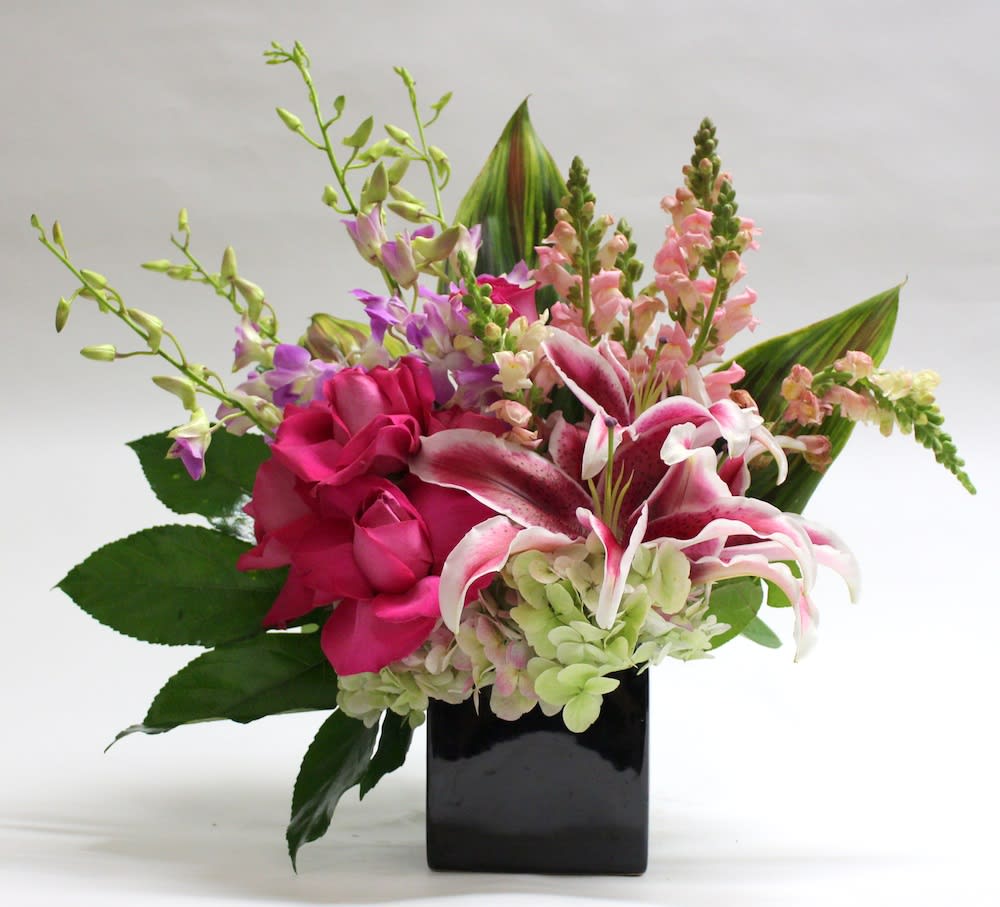 Pink lilies and roses in a black square vase