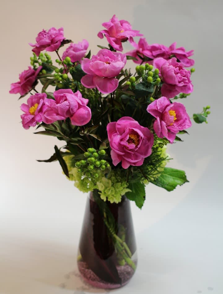 Pink flowers arranged in a dark glass vase