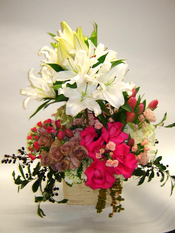 Mixed bouquet of white lilies and pink roses in a box
