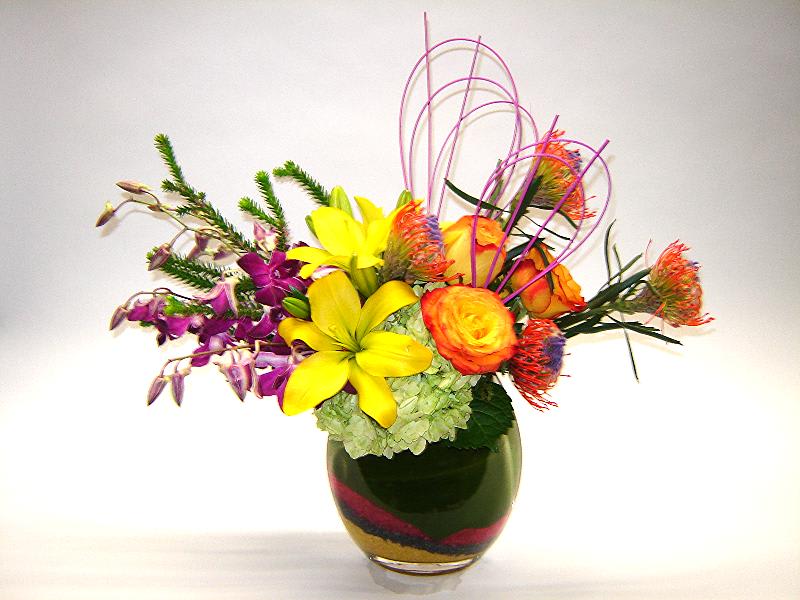 Bright mixed bouquet in a glass vase with yellow and orange blooms