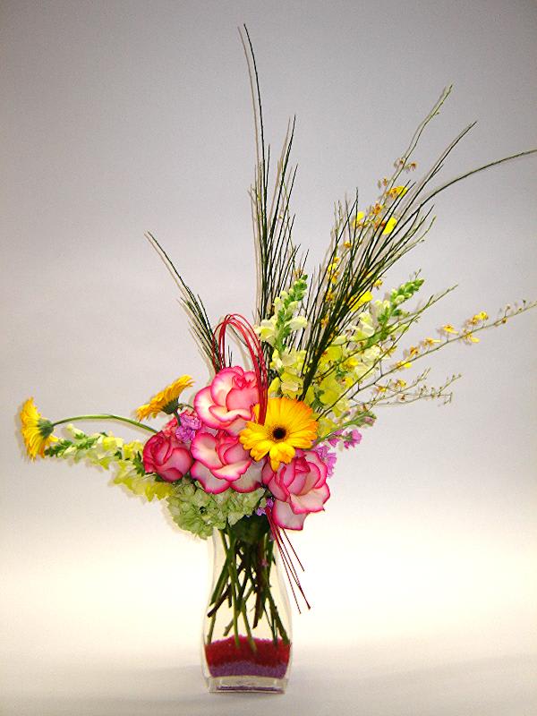 Tall vase arrangement with pink roses and yellow gerbera daisies