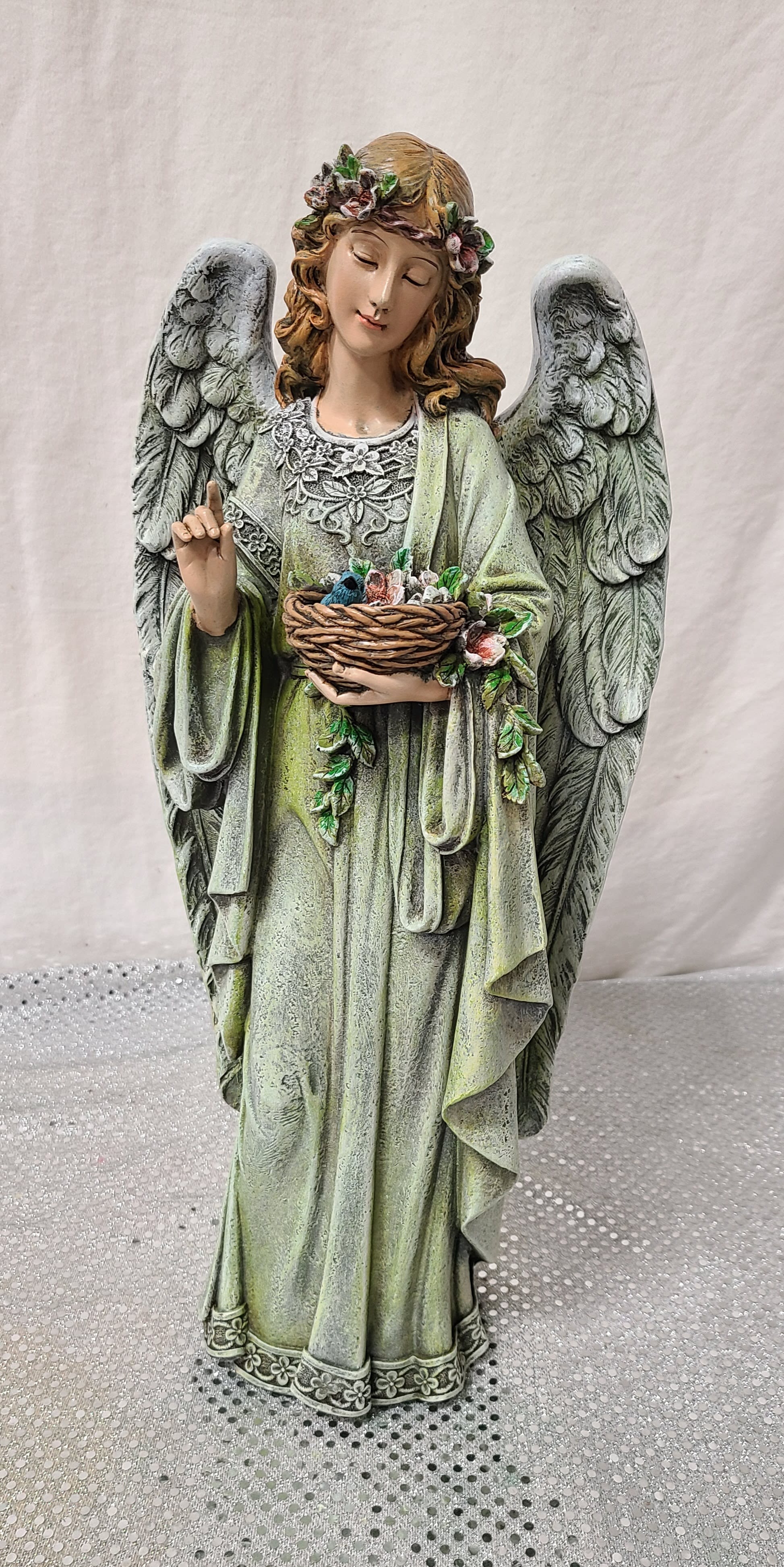 Angel statue holding a basket of flowers