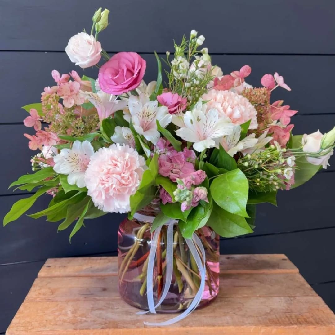 Pink and white mixed flower arrangement in a glass vase
