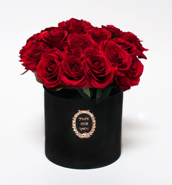Red roses arranged in a black cylindrical box