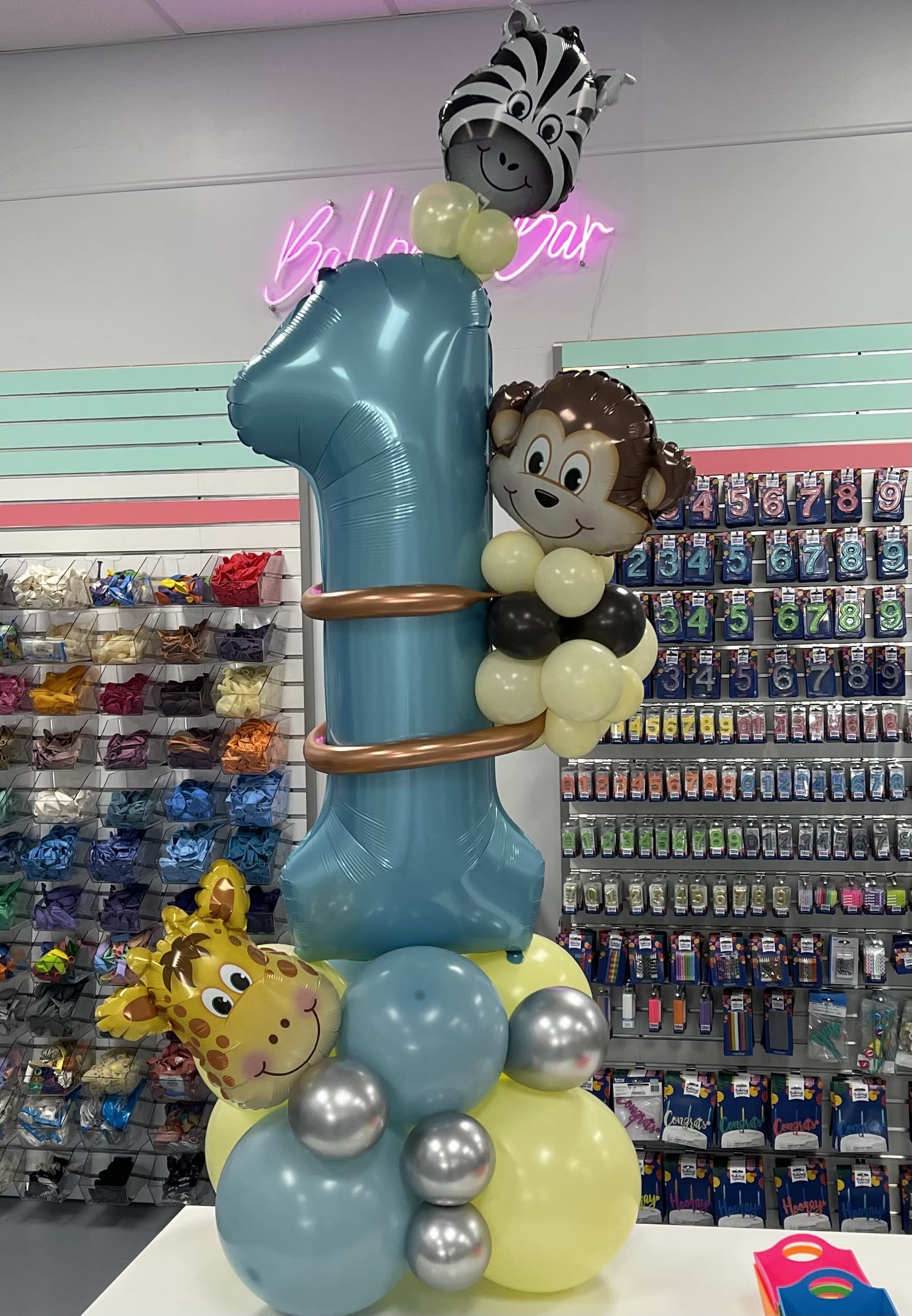 Balloon tower with a large blue number 1 and animal face balloons