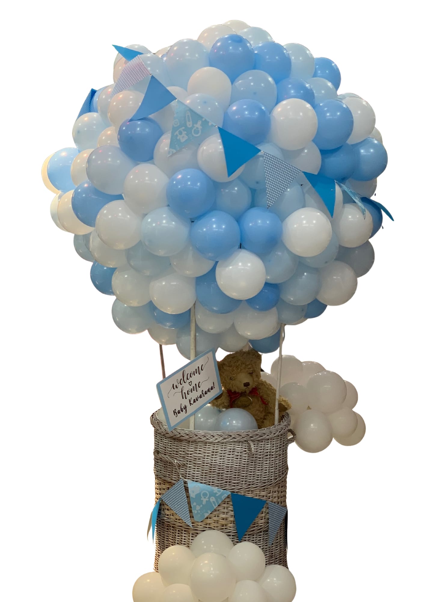 Blue and white balloon arrangement in a wicker basket with a teddy bear