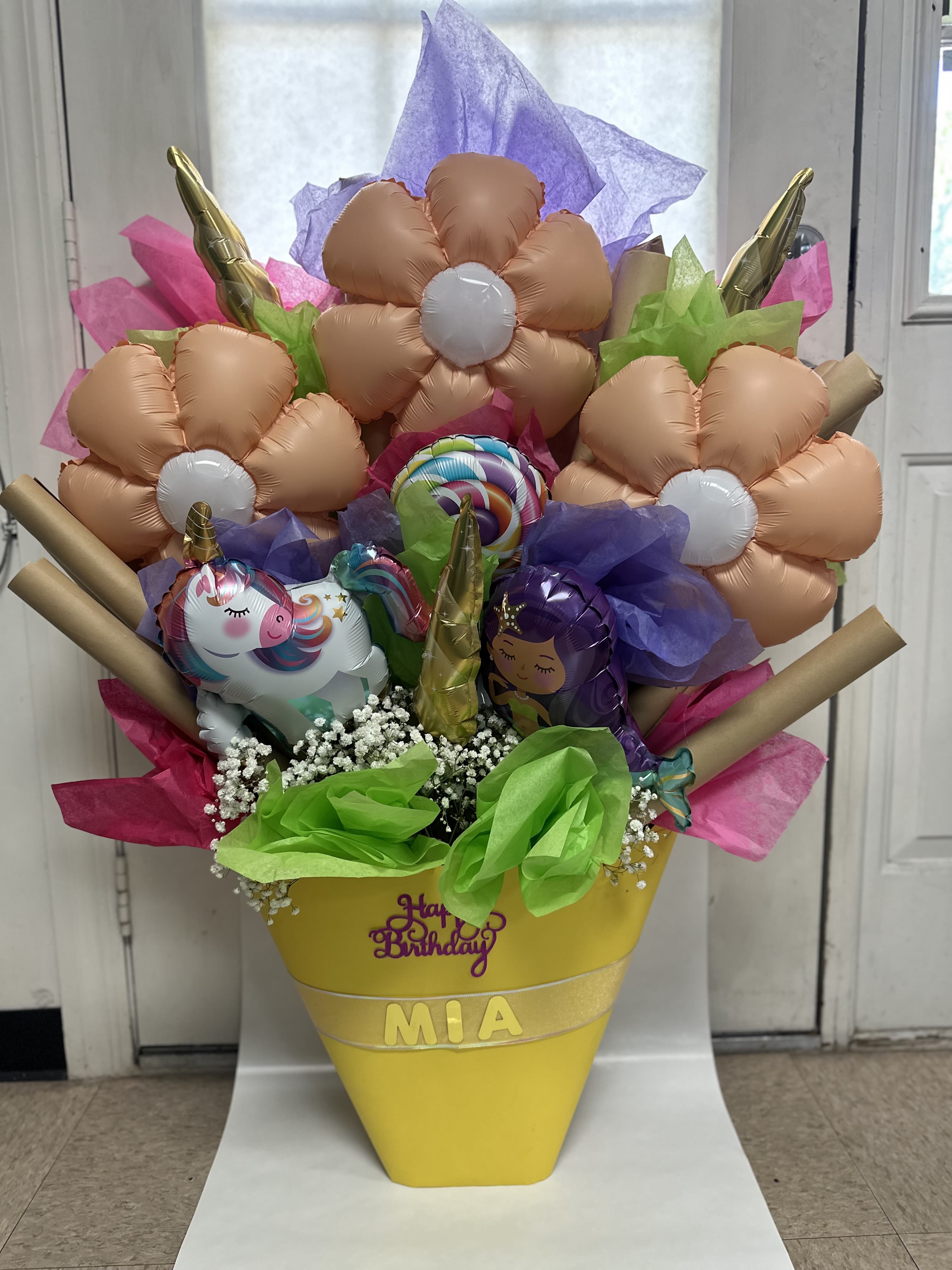 Birthday balloon bouquet in a yellow cone with unicorn balloons and tissue paper