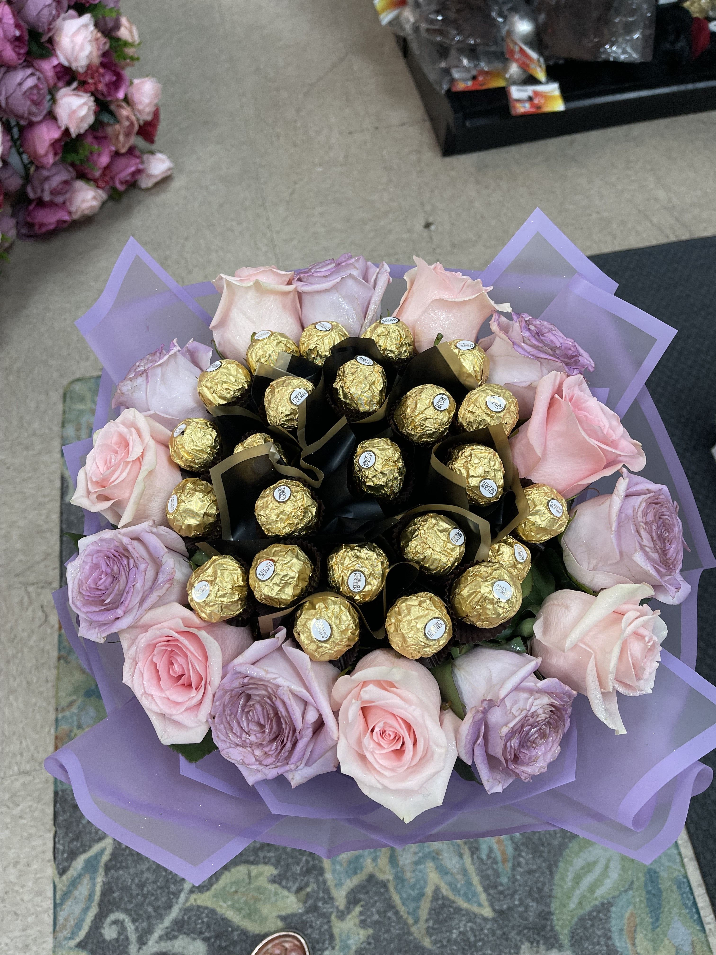 Bouquet of pink and lavender roses with gold-wrapped chocolates