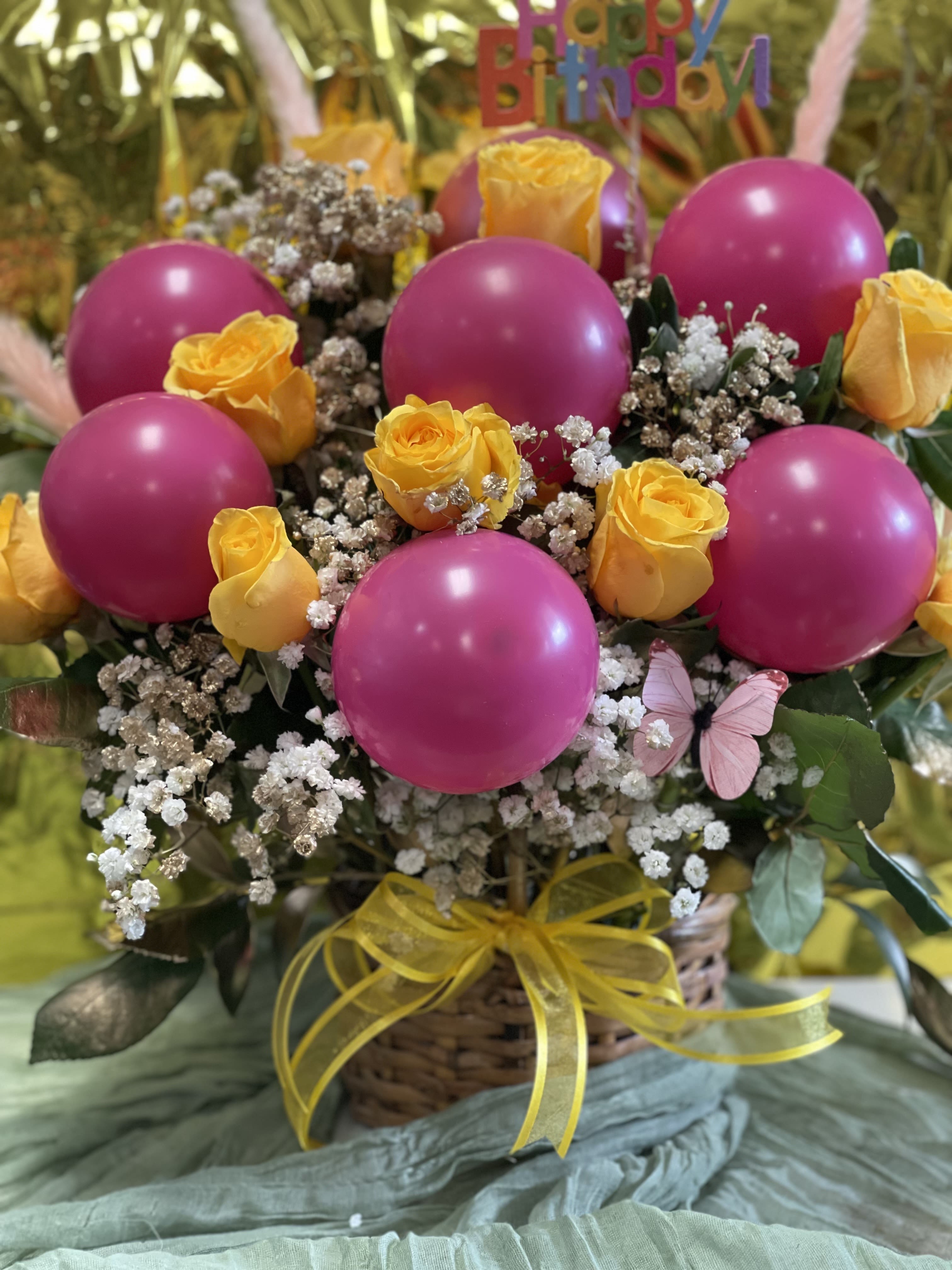 Basket arrangement with yellow roses and pink balloons