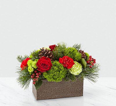 Red roses and carnations in a rectangular box with pine and berries