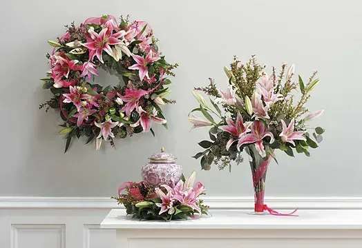 Pink lily floral wreath, bouquet, and centerpiece on a white table