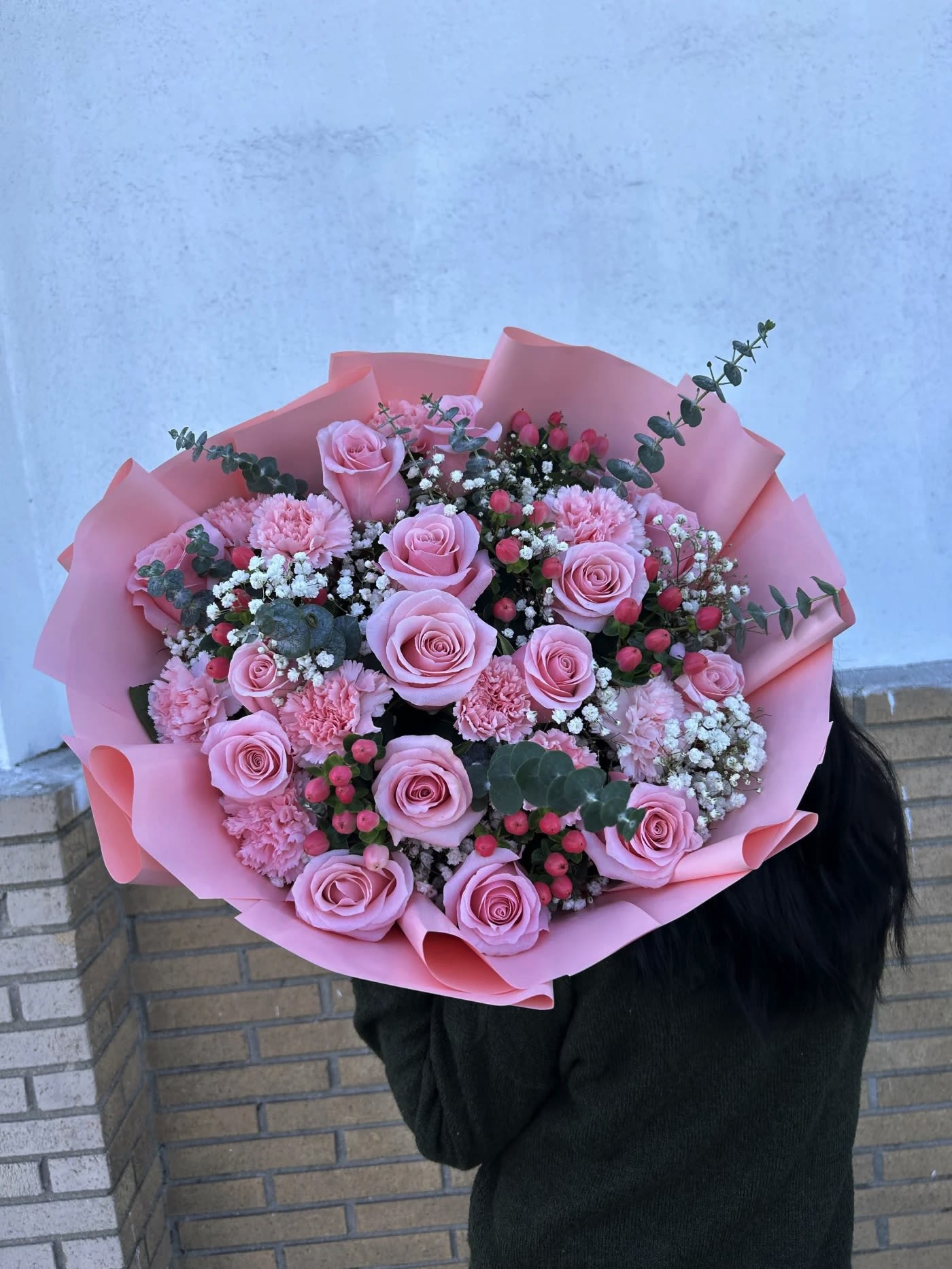Large bouquet of pink roses and carnations wrapped in pink paper