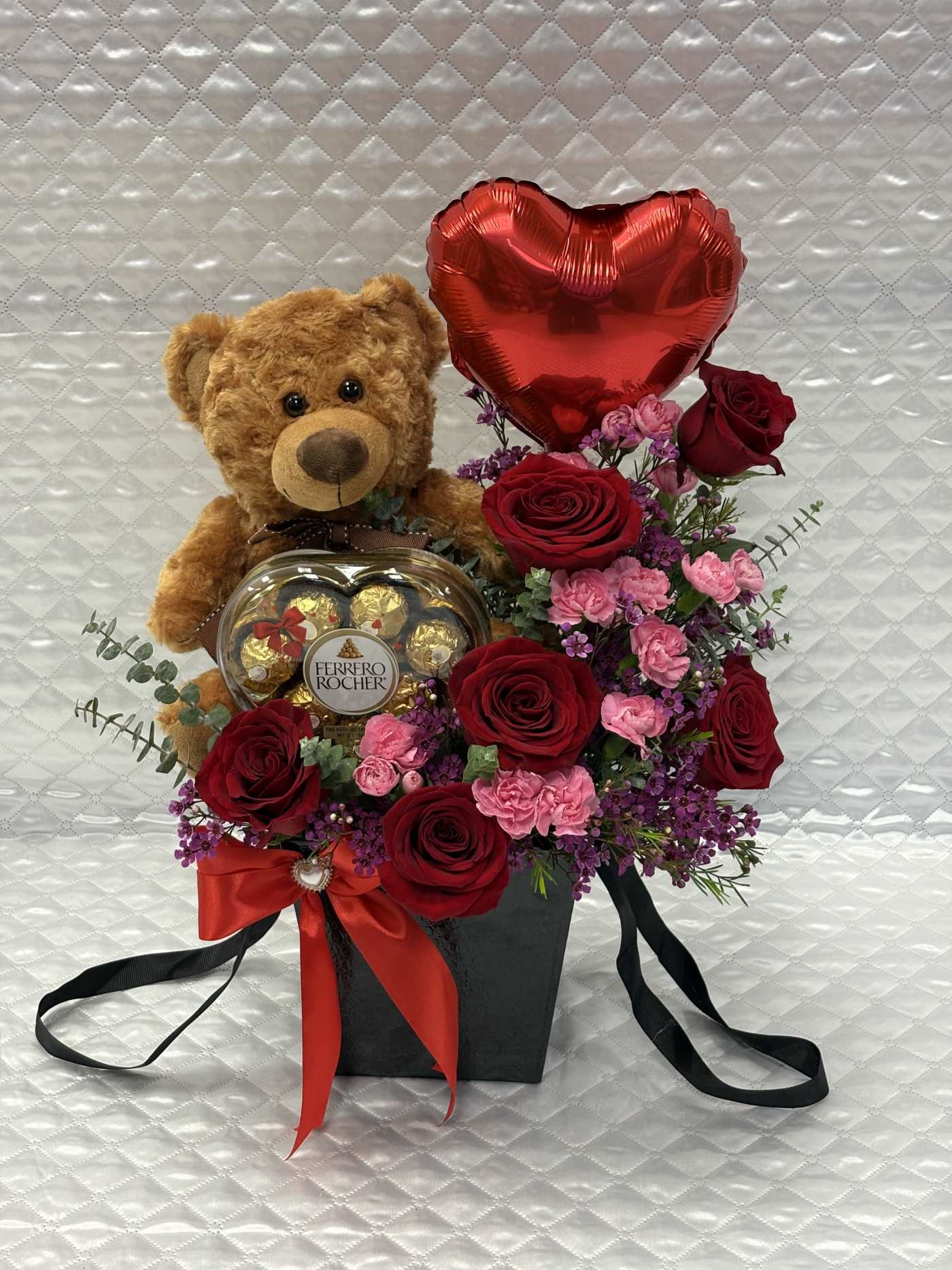 Teddy bear with roses, heart balloon, and chocolates in a black box