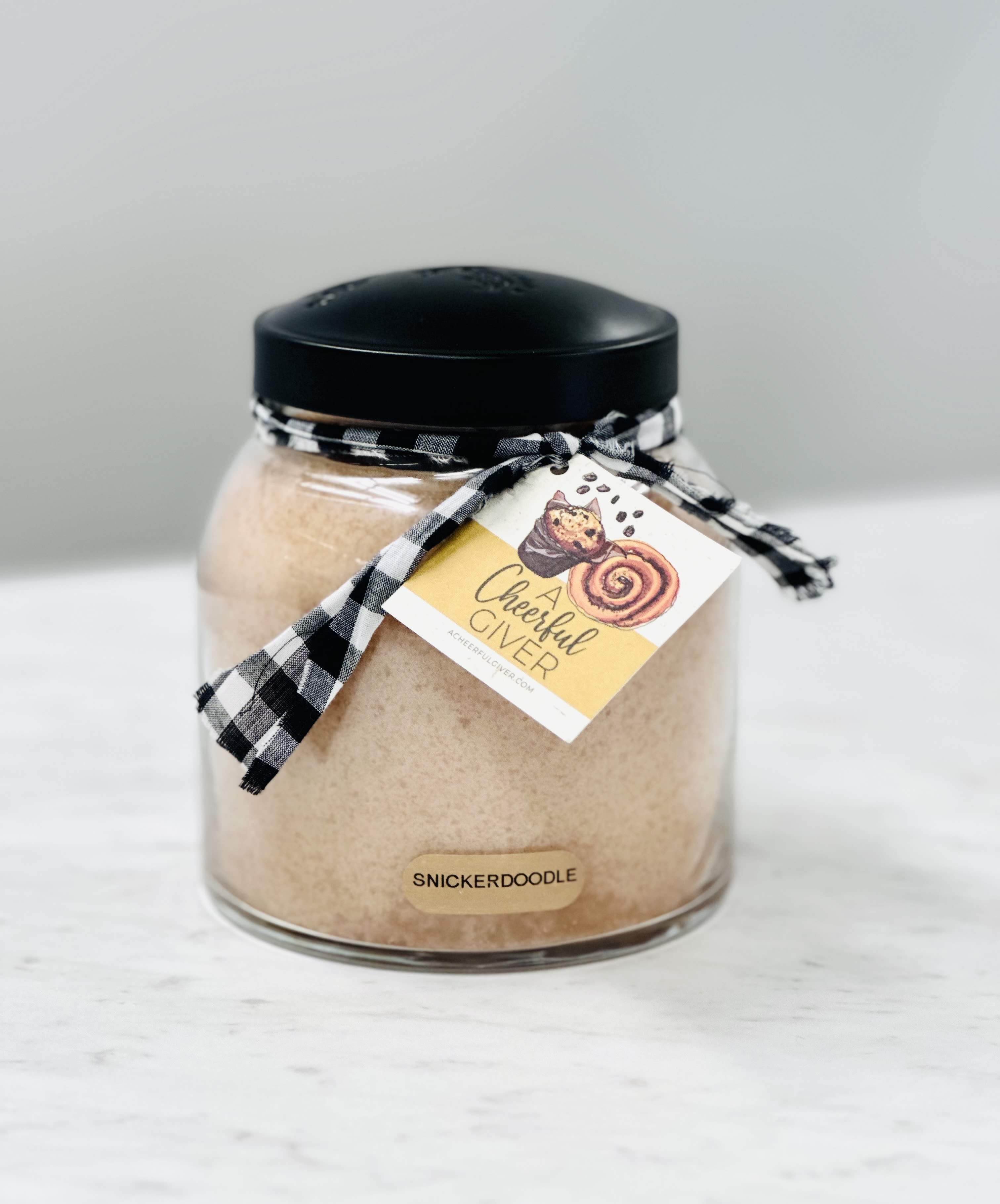 Jar of snickerdoodle mix with a black lid and ribbon tag