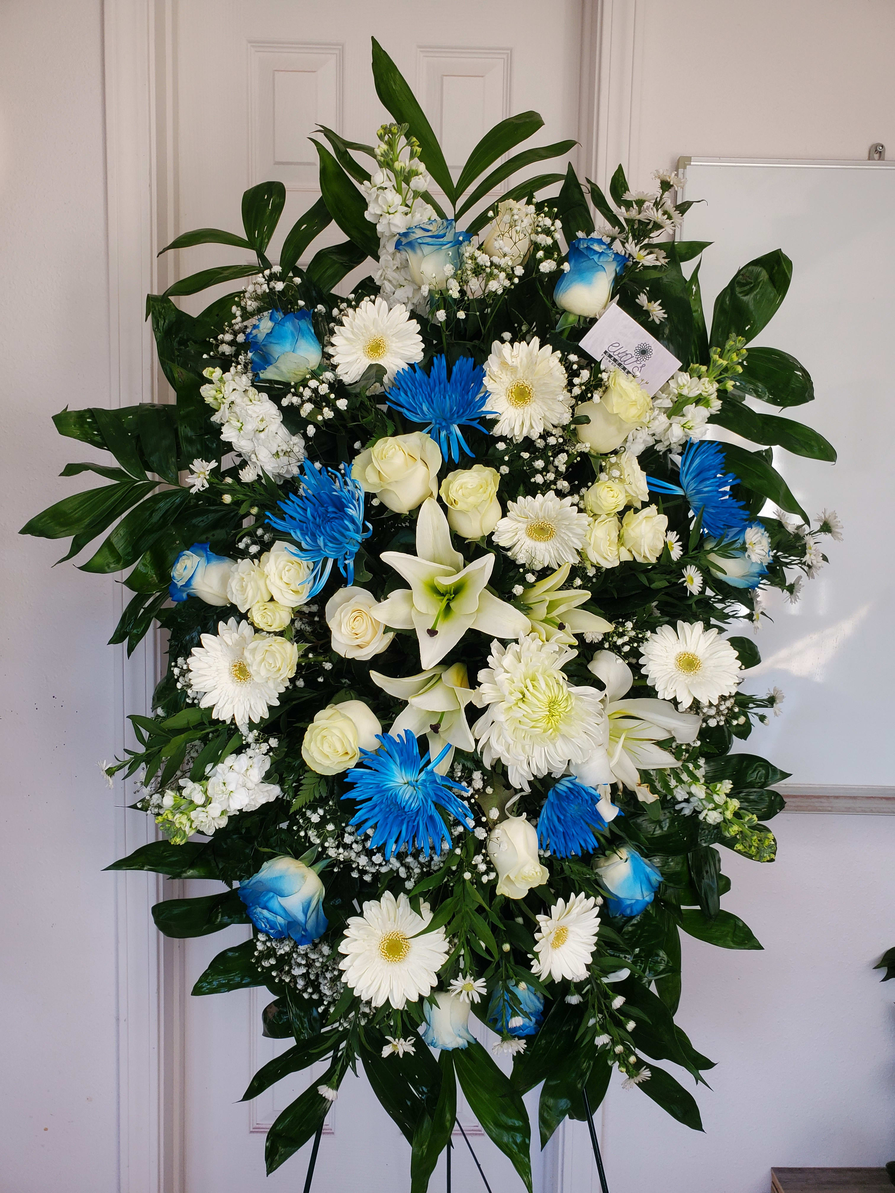Large standing floral spray with white and blue flowers on an easel
