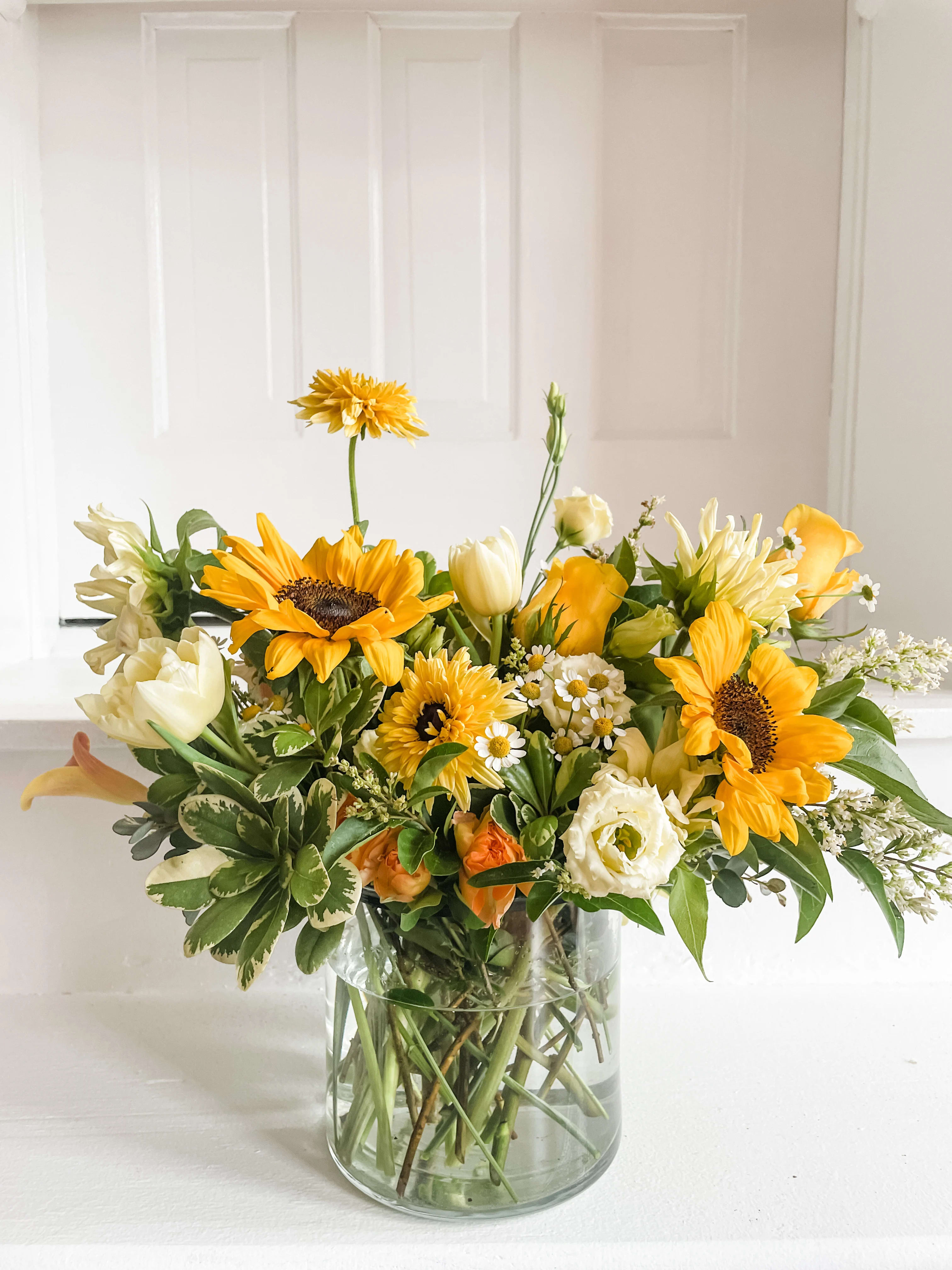 Yellow and white mixed bouquet in a clear glass vase