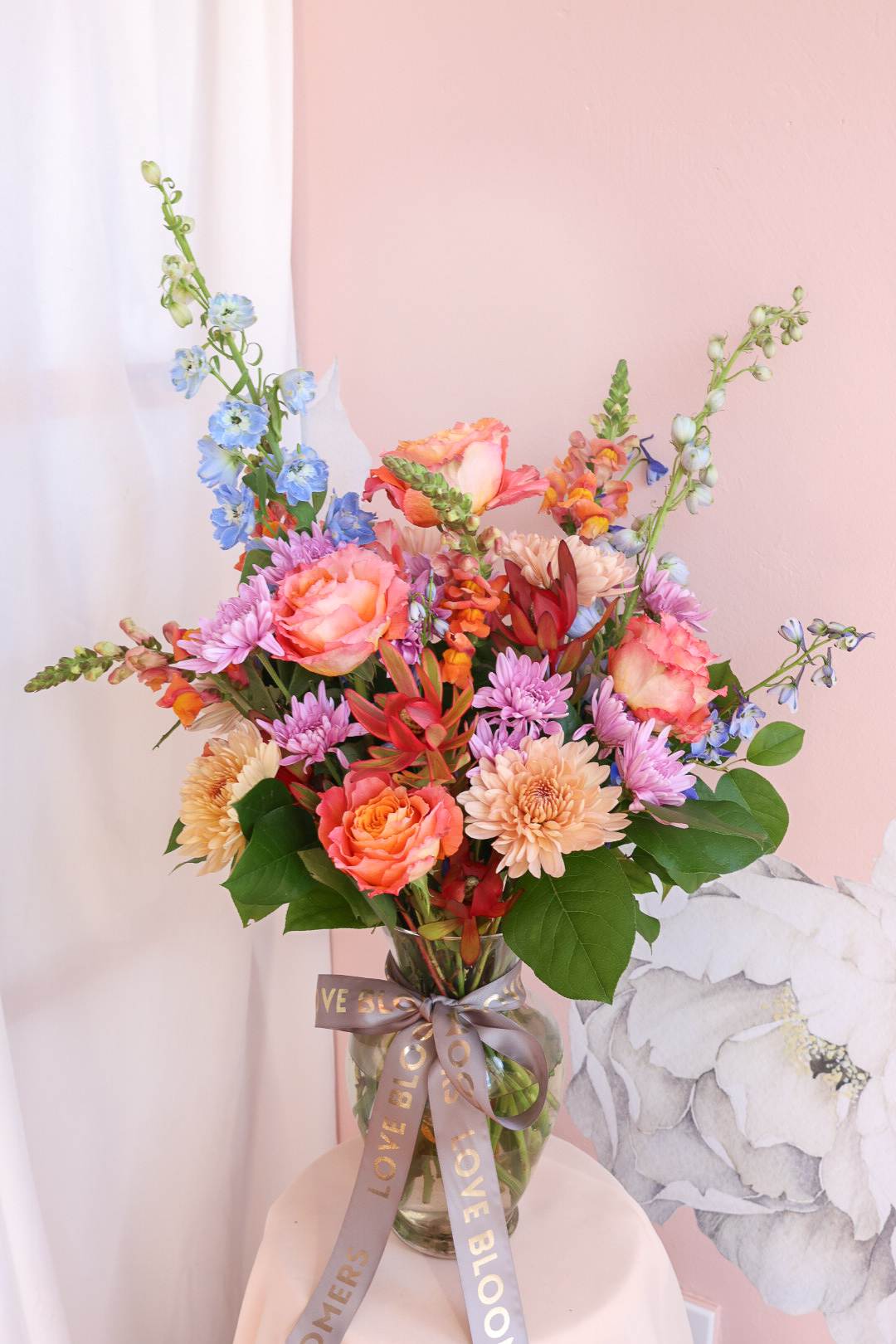 Colorful mixed bouquet in a glass vase with a ribbon