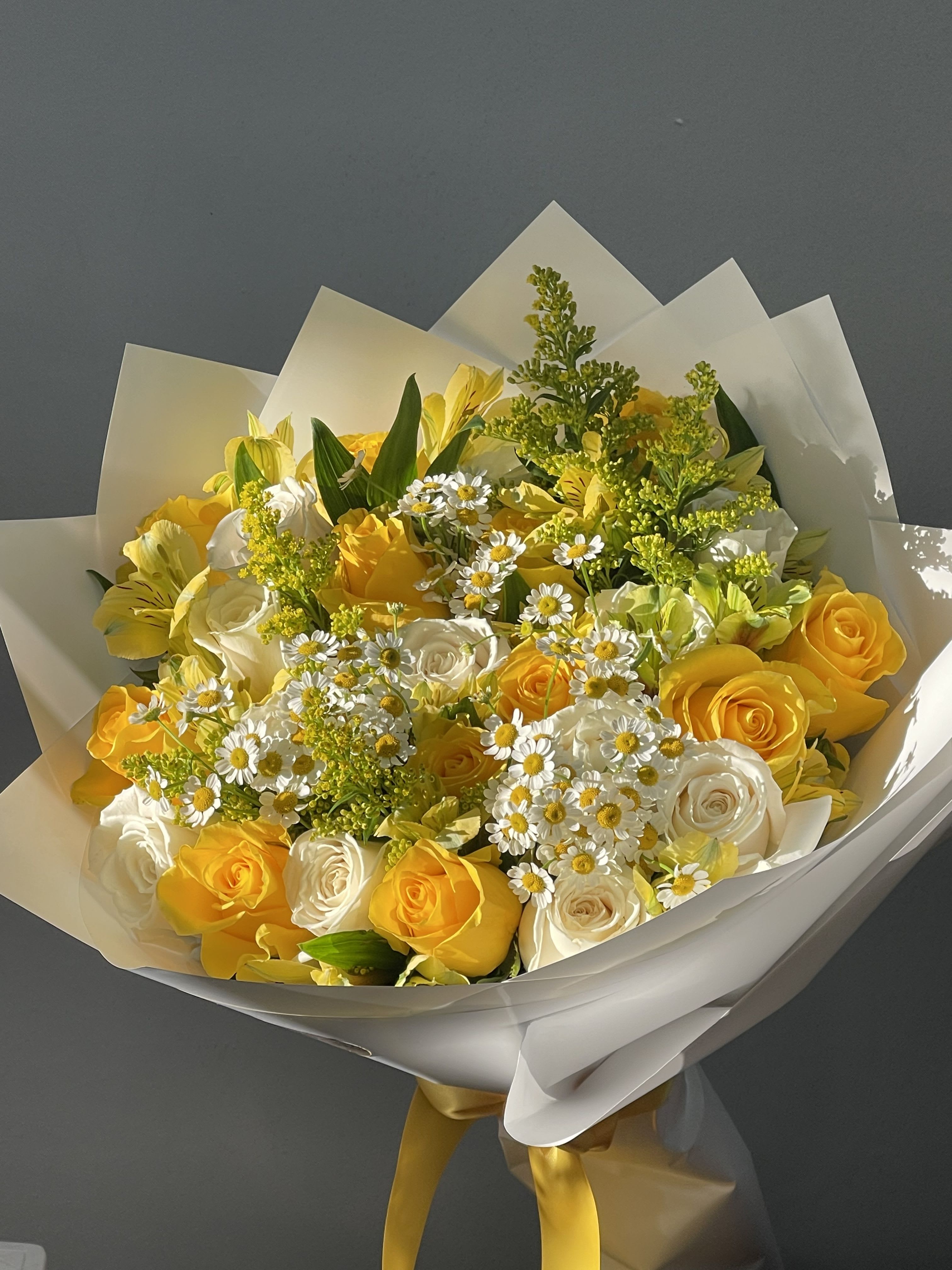 The delicate sunrise bouquet  - yellow and white long stem roses with a variety of filler flowers wrapped in korean wrapping paper 