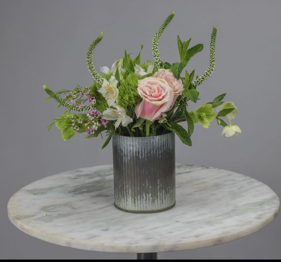 Pink roses and white flowers in a ribbed metal vase