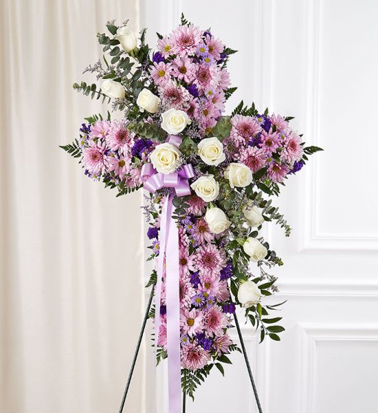 Peace in our Hearts  - Lavender schemes cross shaped easel shows your everlasting love. Featuring a variety of lavender blooms and greenery, this heart with a trail of ivy compliments the beauty of life. The perfect standing arrangement for any funeral service in Los Angeles.