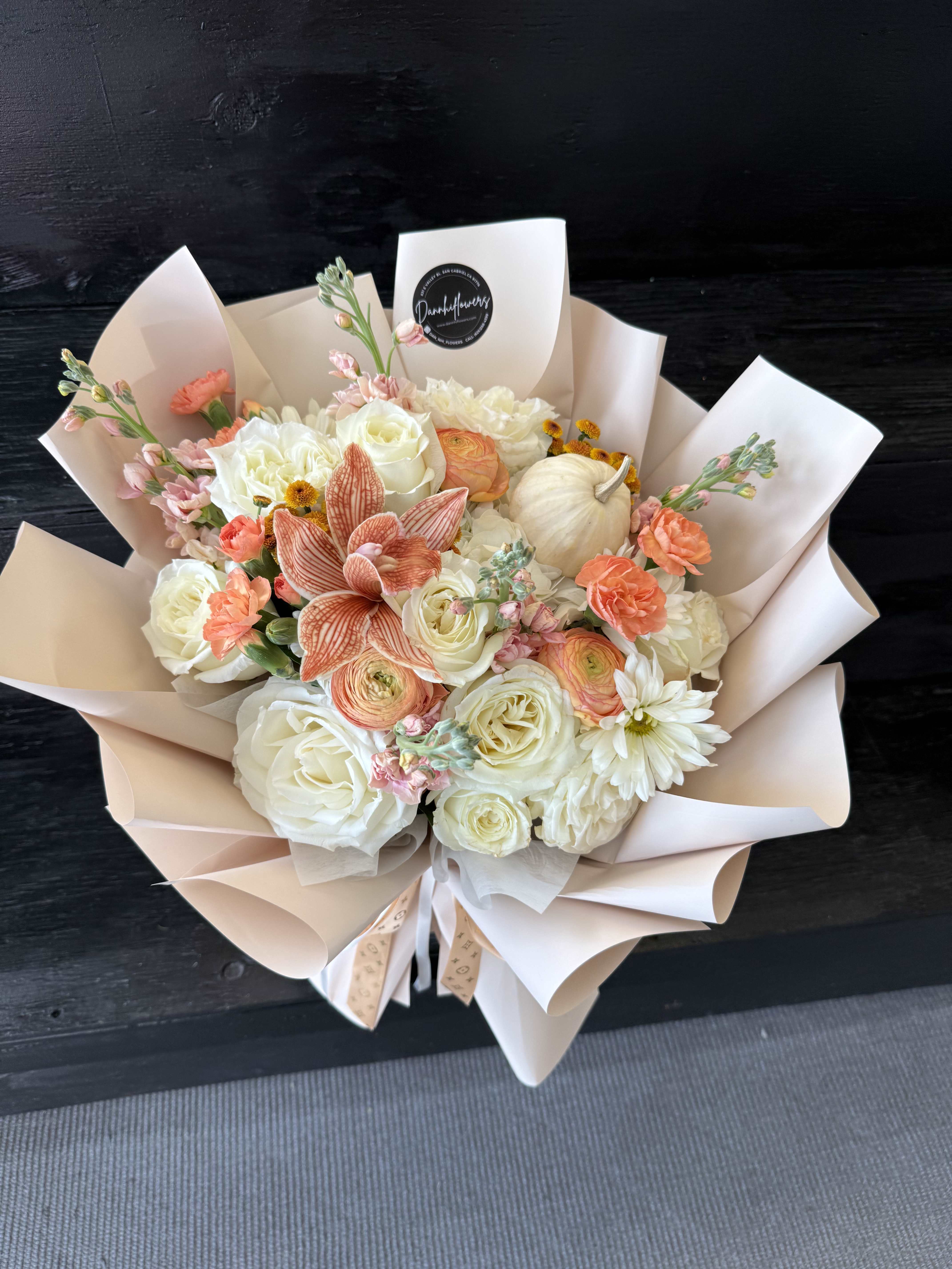 Bouquet of white and peach flowers wrapped in pale paper