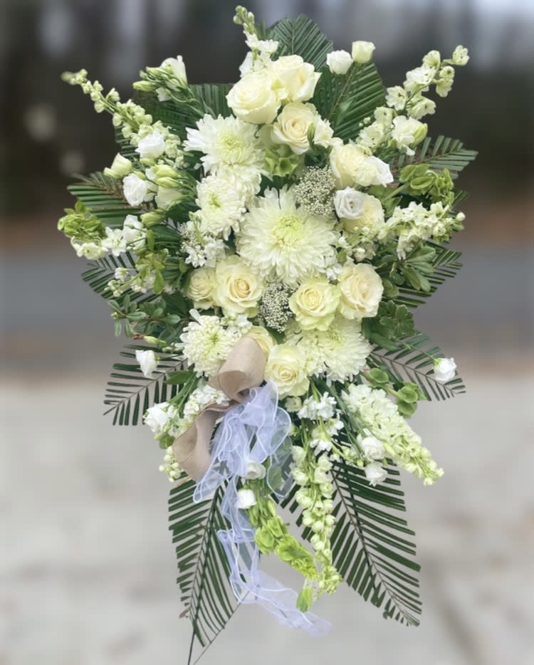 Woodstock on the Green Floral Spray - Honor your loved one with our classic Greenwich funeral spray. It sets a tone of class with luscious  roses, lisianthus, mums and seasonal florals. Spray can also be ordered as a casket spray in deluxe.