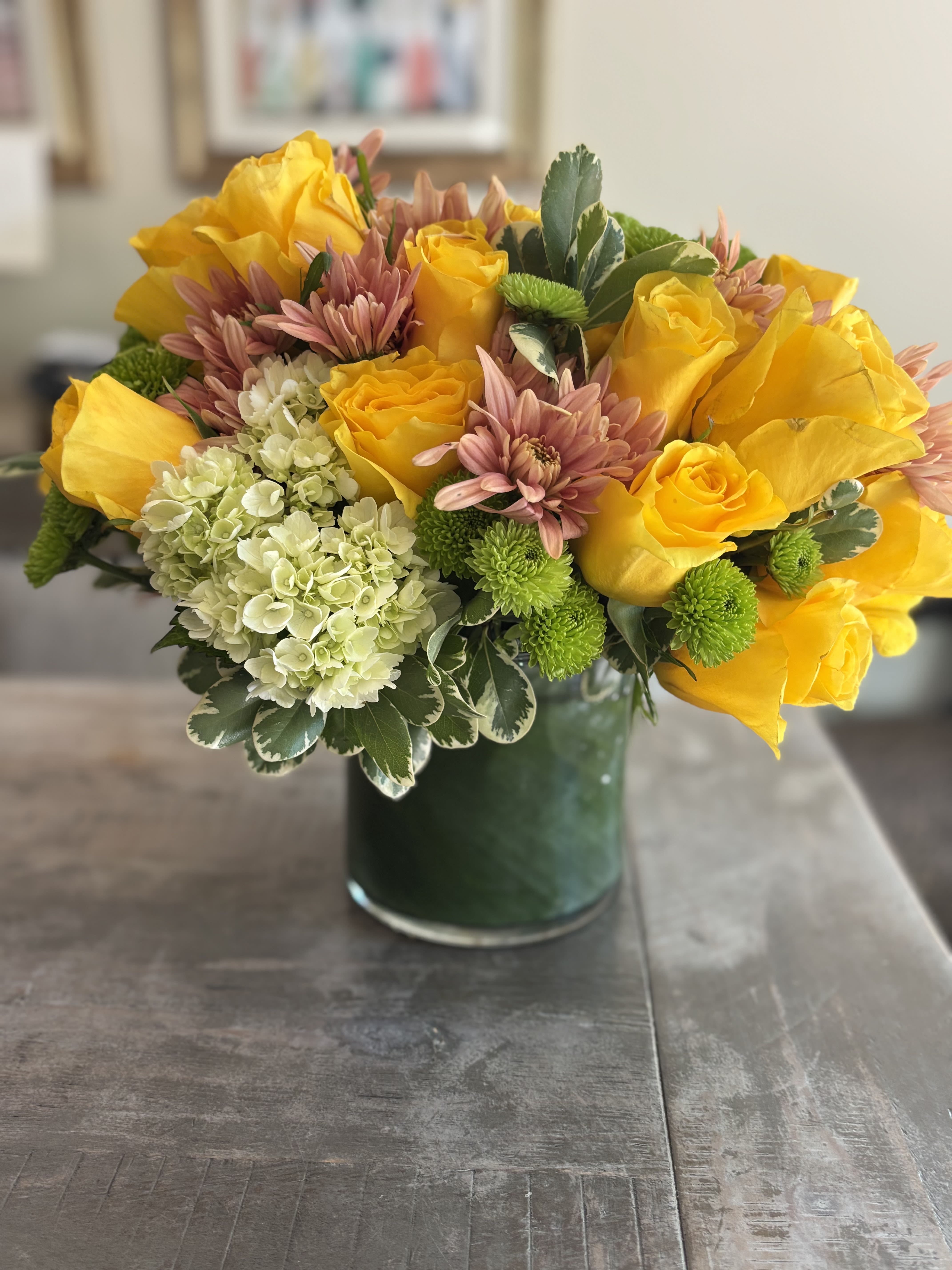 Lady Waleska - Yellow roses and hydrangeas are paired with peach flowering carnations and seasonal greenery.