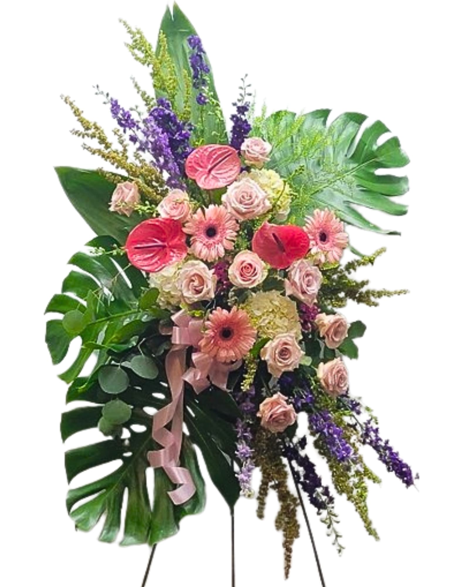 Sending Love Standing Spray - This standing spray features a vibrant and diverse array of flowers, meticulously arranged to create a stunning and colorful tribute. The design showcases a harmonious blend of blooms in various shades, including rich reds, bright yellows, soft pinks, and deep purples, complemented by lush greenery. The composition forms an elegant vertical display, perfect for honoring a special occasion or paying tribute in a meaningful way. Each flower type and color is thoughtfully chosen to add depth and texture, resulting in a beautiful and eye-catching arrangement. 