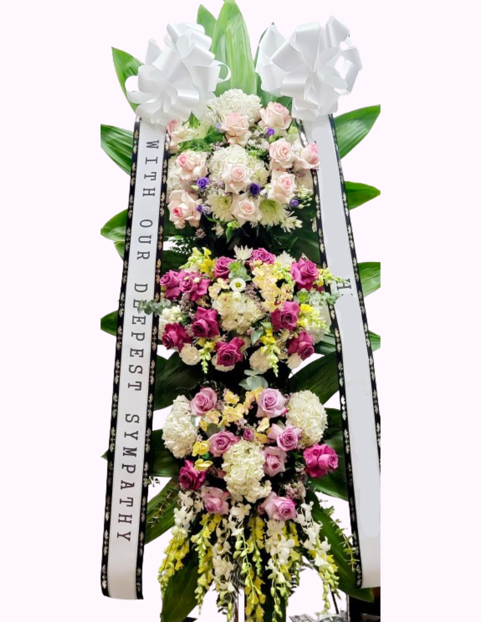 Tall sympathy standing spray with pink and white roses and ribbons