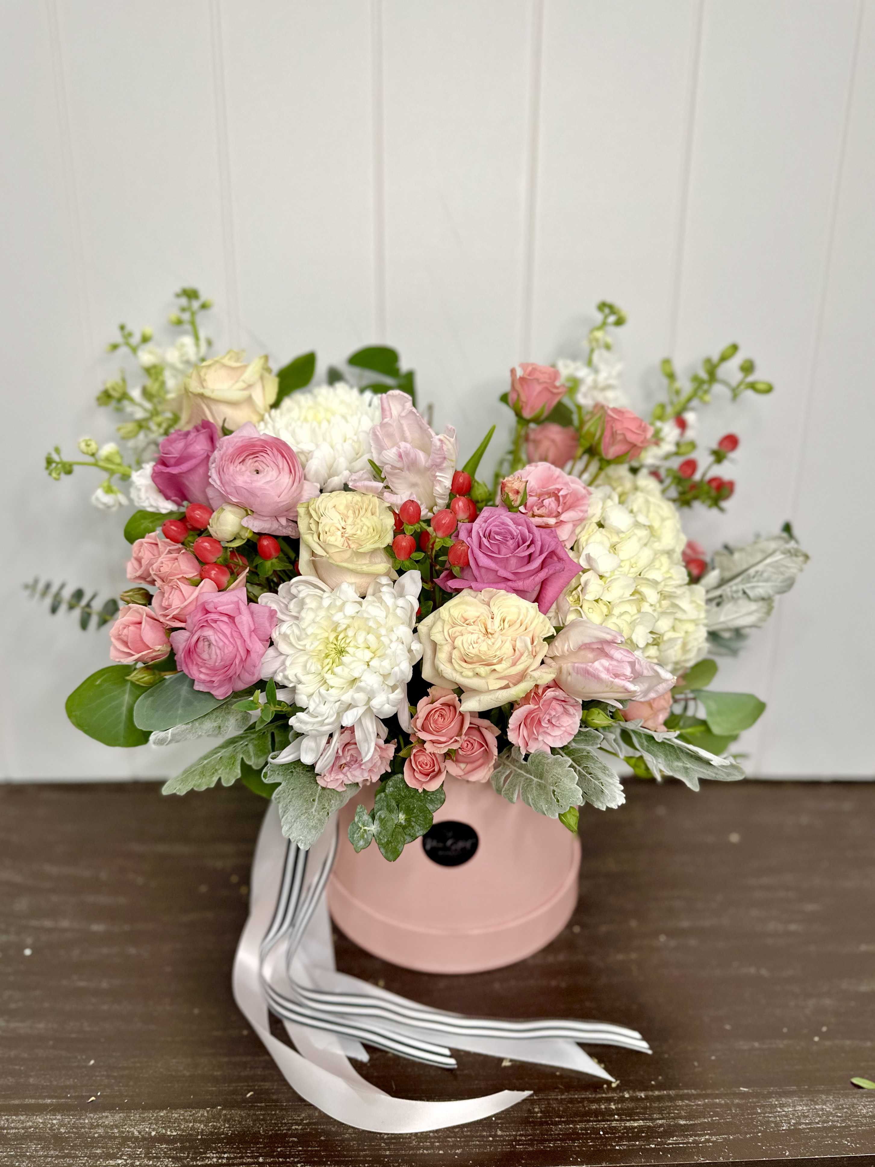 Pink and white rose bouquet in a pink hat box with ribbon.