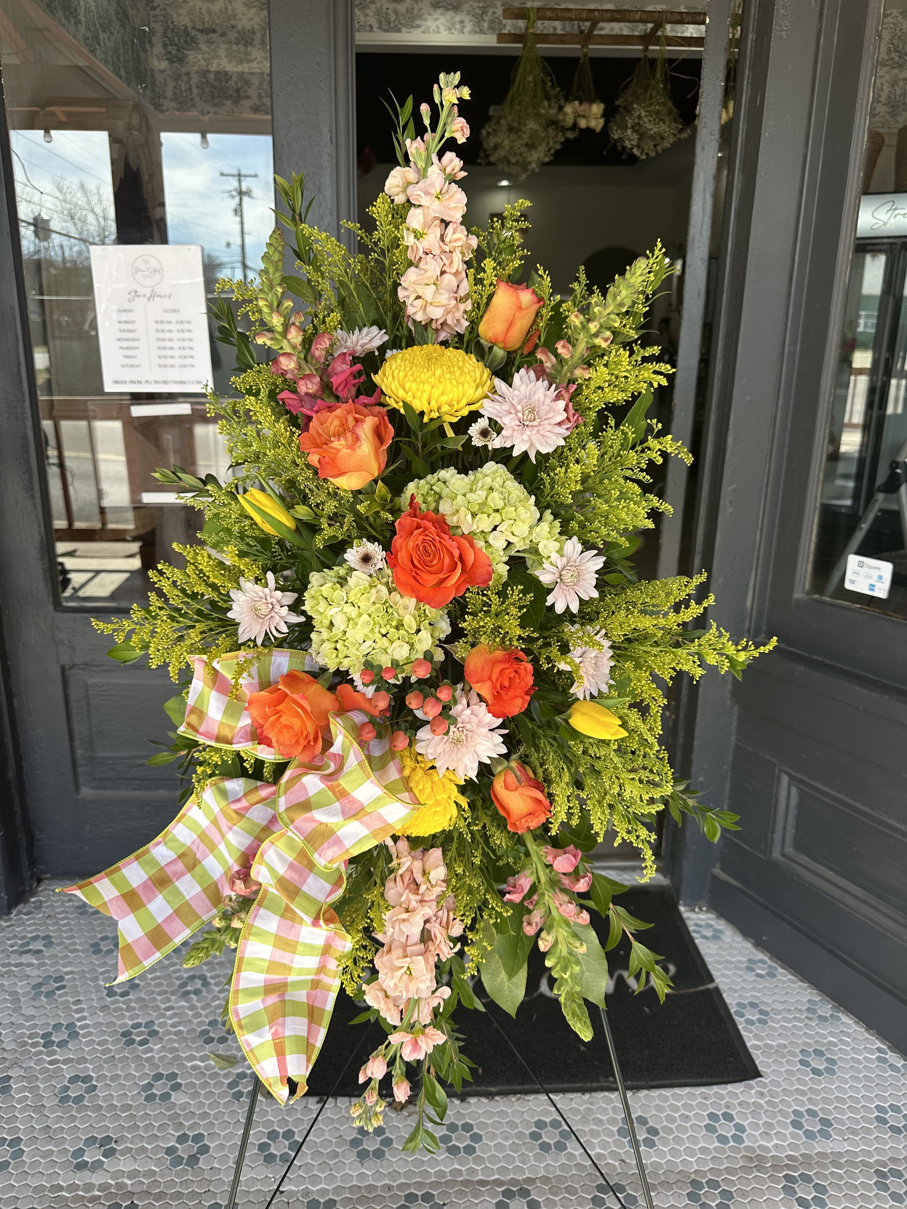 Tall floral standing spray with orange roses and yellow chrysanthemums