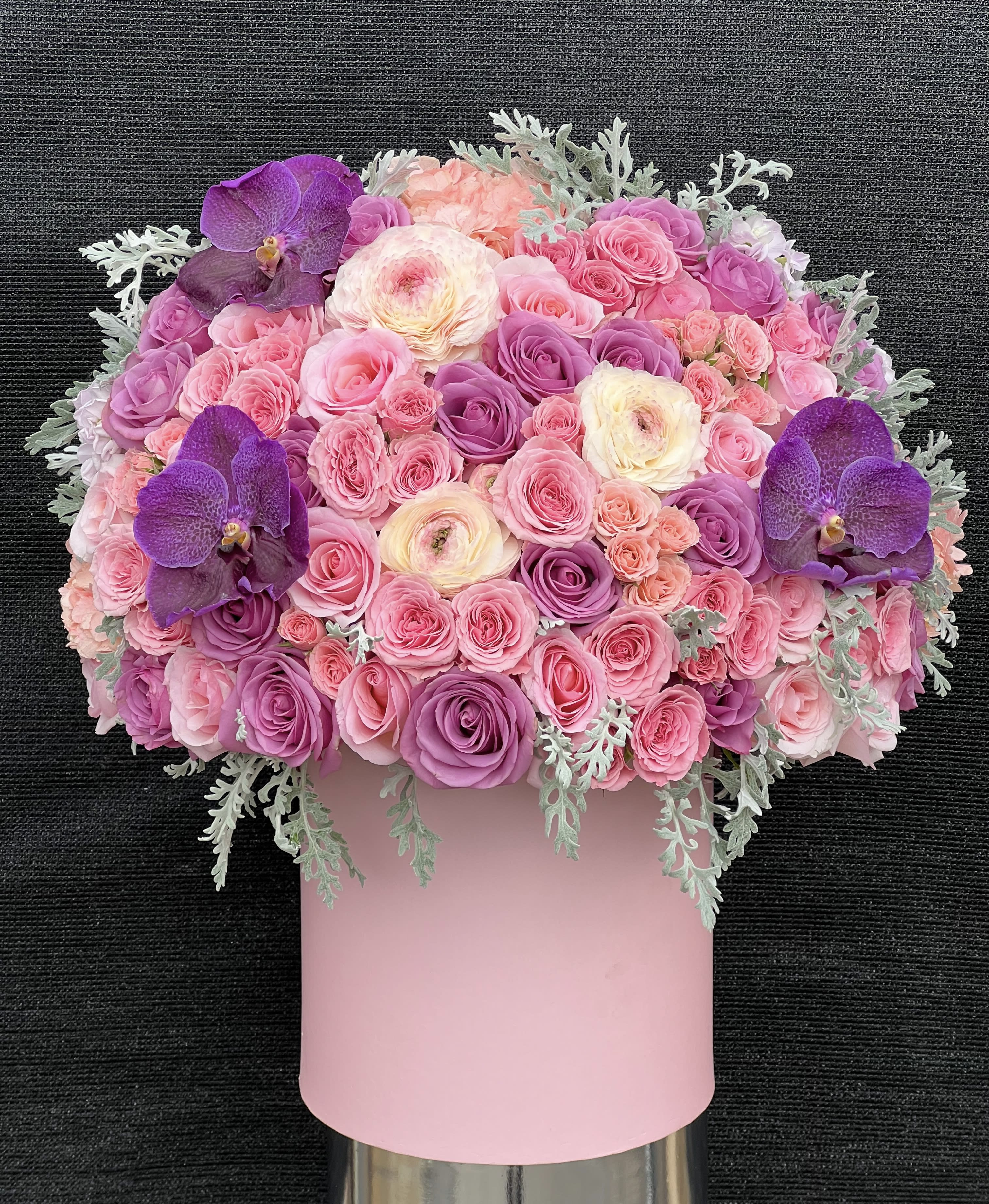 Pink and purple rose bouquet with orchids in a pink box