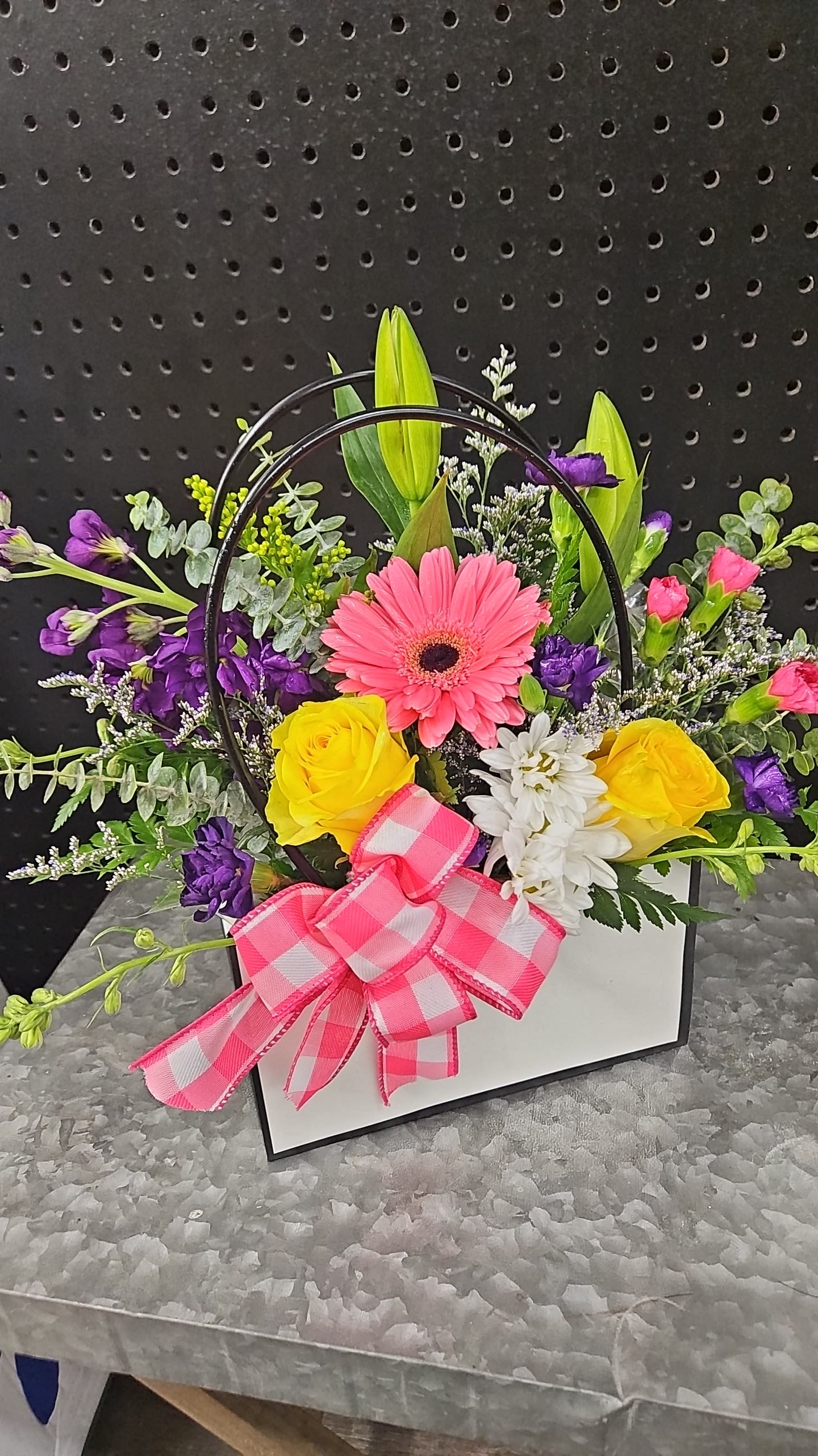 Mixed flower arrangement in a white box with a pink bow