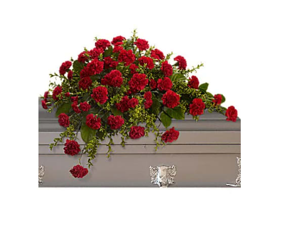 Red carnation spray on a gray casket