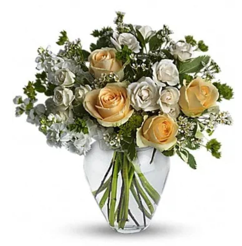 Bouquet of cream and white roses in a clear glass vase