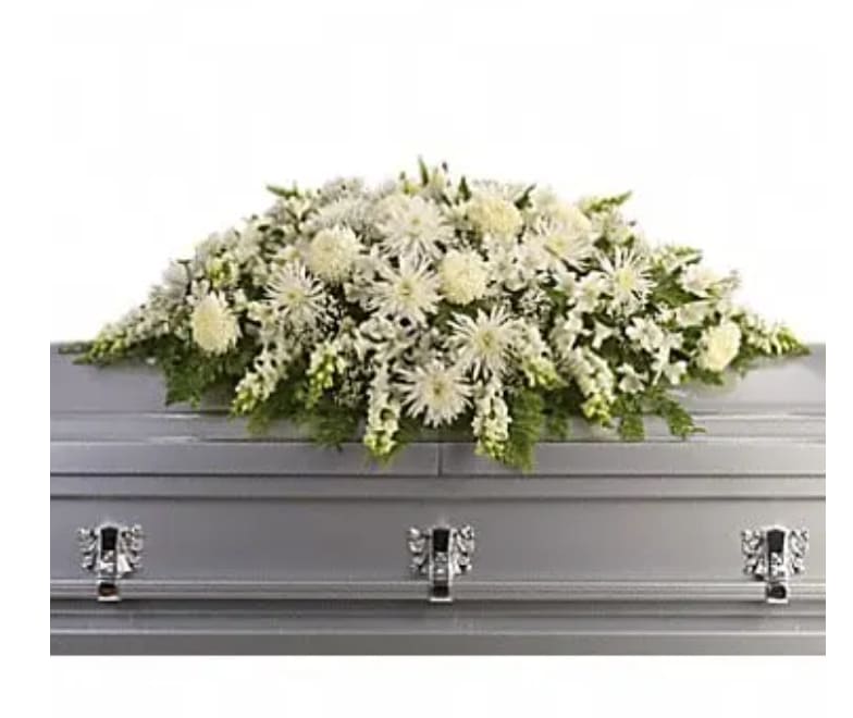 White floral casket spray on a gray casket