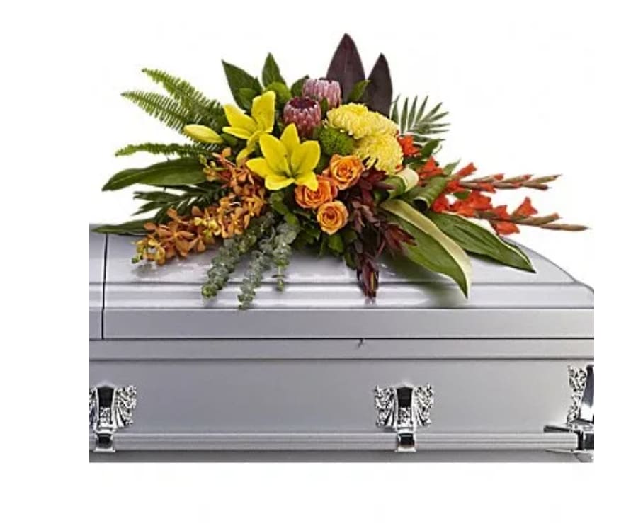 Bright floral spray on a silver casket