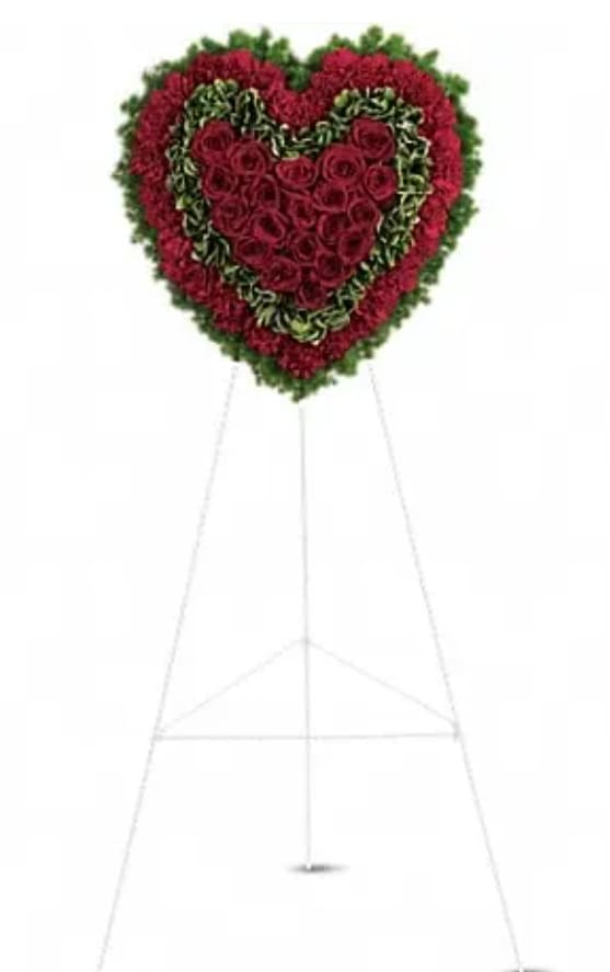 Heart-shaped standing floral tribute with red roses and greenery
